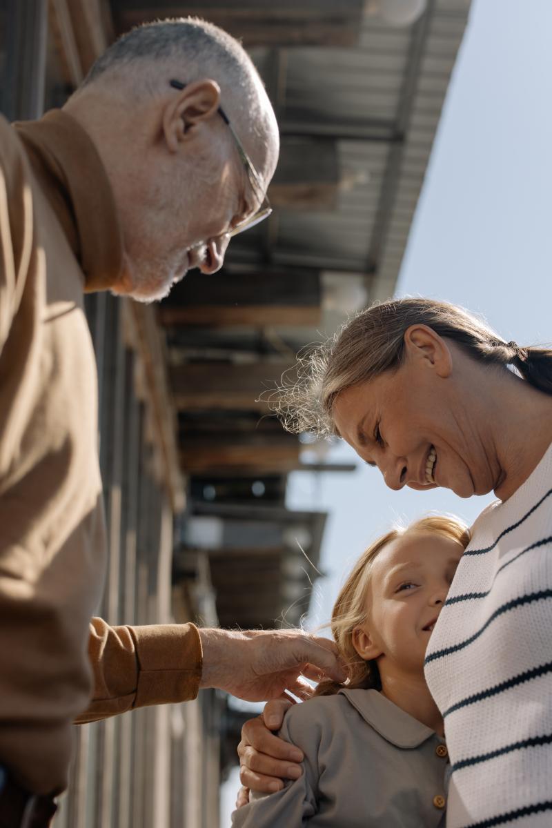 Two grandparents looking at their granddaughter