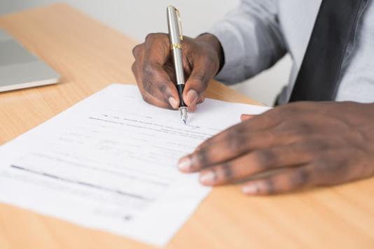A man signing a healthcare document 