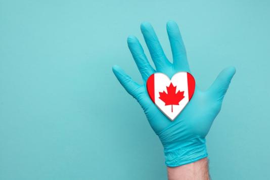 A medical glove with a Canadian flag on top of it